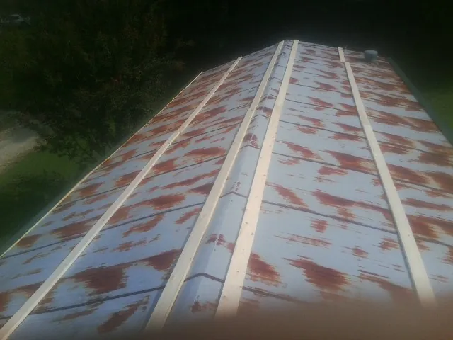 Rusted metal roof panels with new wood purlins before replacement — Storm Damage Roof Repair in New Port Richey by Roofing Brothers