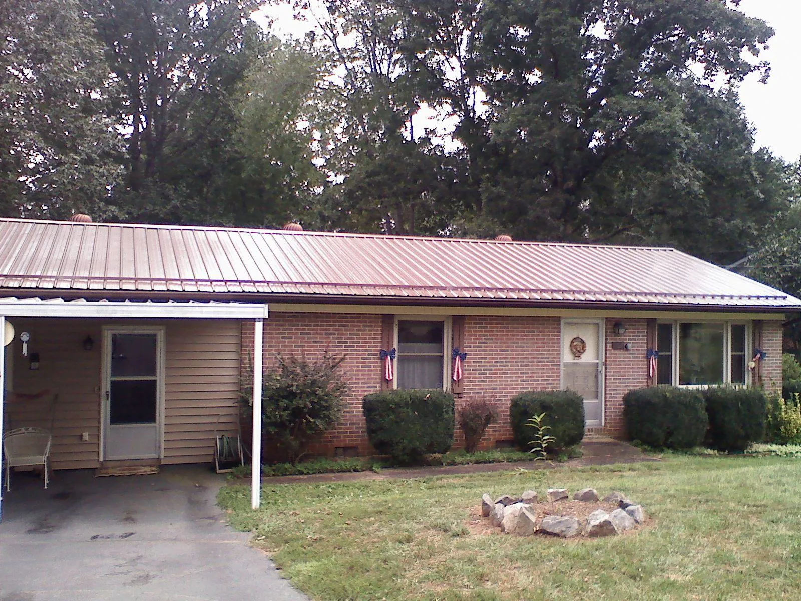Bronze metal roof and carport on a brick ranch home — Roof Repair work by our crew in New Port Richey